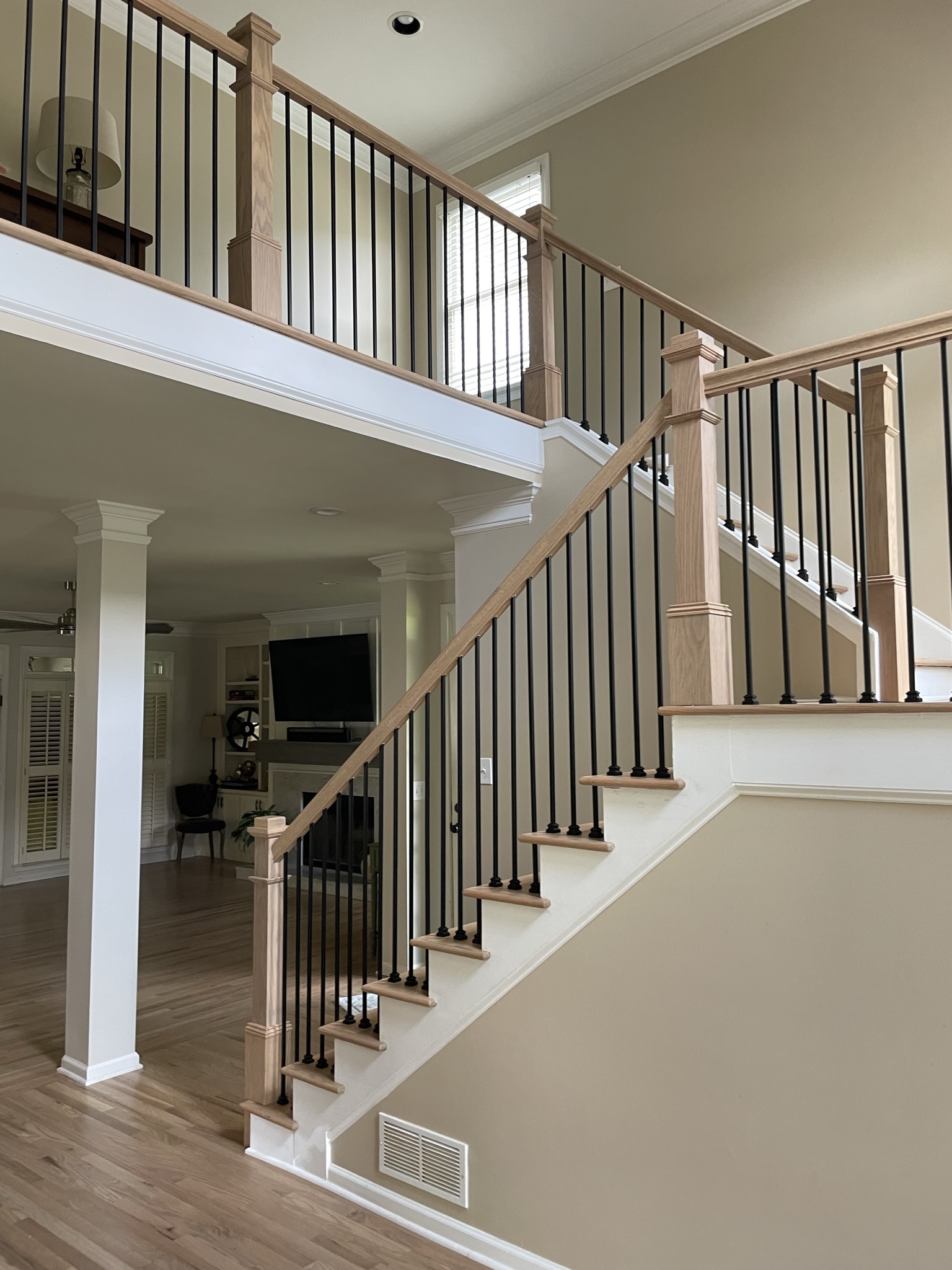Light color stairs and black iron balusters 